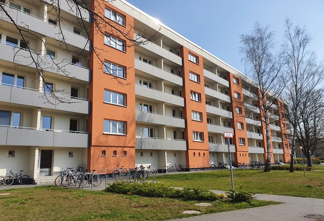 Außenansicht des fünfgeschossigen, weiß-orangen Wohnheims im Ernst-Thälmann-Ring.