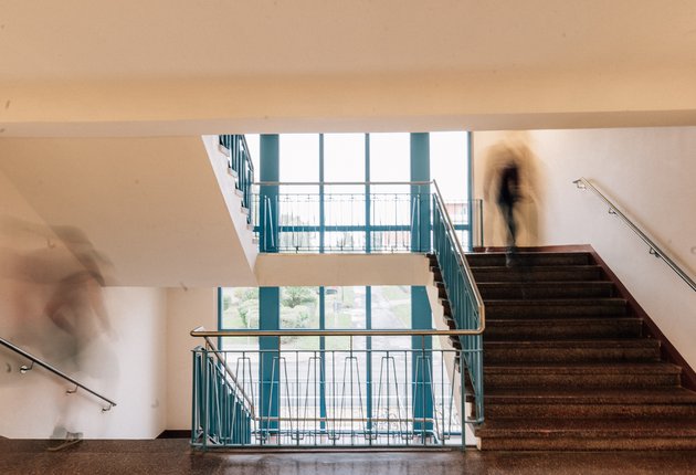 Treppenhaus des Wohnheims mit zwei Menschen, die die Treppe hoch beziehungsweise runter gehen.