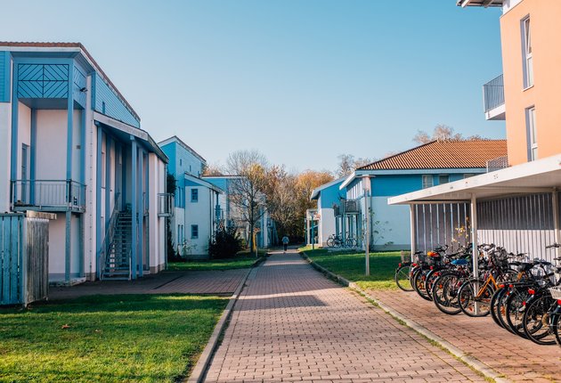 Weg durch die Häuser der Wohnheimanlage Fleischerwiese Komplex 1. Rechts: überdachte Fahrradständer mit Fahrrädern.